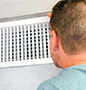 Man checking heating vent