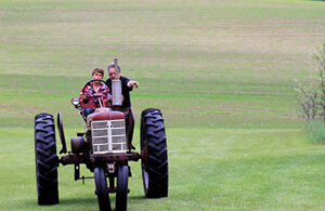 Man and child riding tractor