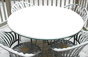 Outdoor porch table and chairs covered in snow